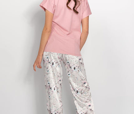 Female model shown from the back wearing a pastel pink short-sleeve cotton T-shirt with a straight cut and white floral print satin wide-leg trousers standing barefoot against a plain white background