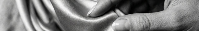 Hand touching satin fabric with a close-up view
