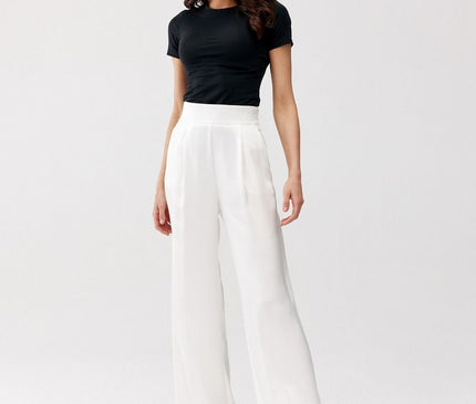 Female model stands in a plain white studio background wearing a fitted black jersey short-sleeve top tucked into high-waisted white wide-leg crepe trousers
