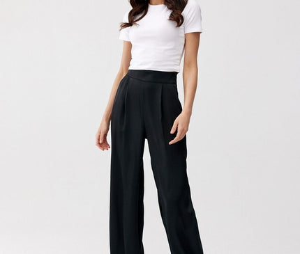 Female model stands against a plain white studio backdrop wearing a white cotton fitted crop t-shirt and black wide-leg satin trousers