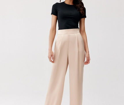 A model stands against a plain white background wearing a fitted black cotton T-shirt and high-waisted cream wide-leg trousers