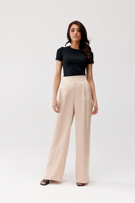 A model stands against a plain white background wearing a fitted black cotton T-shirt and high-waisted cream wide-leg trousers