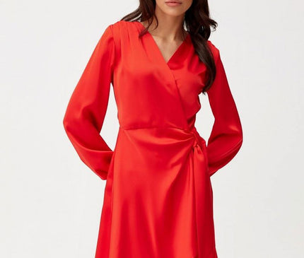 A female model stands against a white background wearing a red satin wrap mini dress with a V-neckline, long sleeves and a tied waist