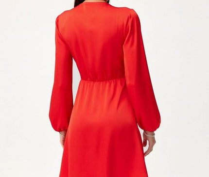 Model wearing a red long-sleeve A-line mini dress in lightweight fabric posed from the back against a plain white background