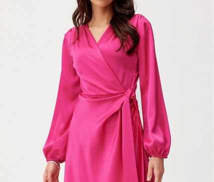 Model wearing a fuchsia satin wrap mini dress with long bishop sleeves standing against a white background