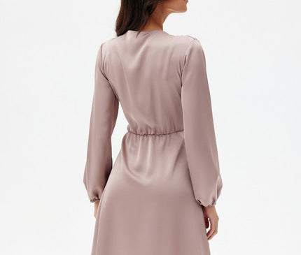 A model stands against a plain white background wearing a mauve satin long sleeve A-line mini dress with a cinched waist and her back to the camera as she turns her head to the side