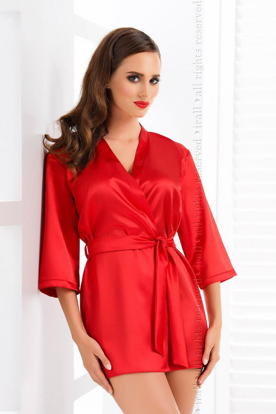 Model wearing a short red satin wrap kimono robe standing against a white wall with a shuttered window
