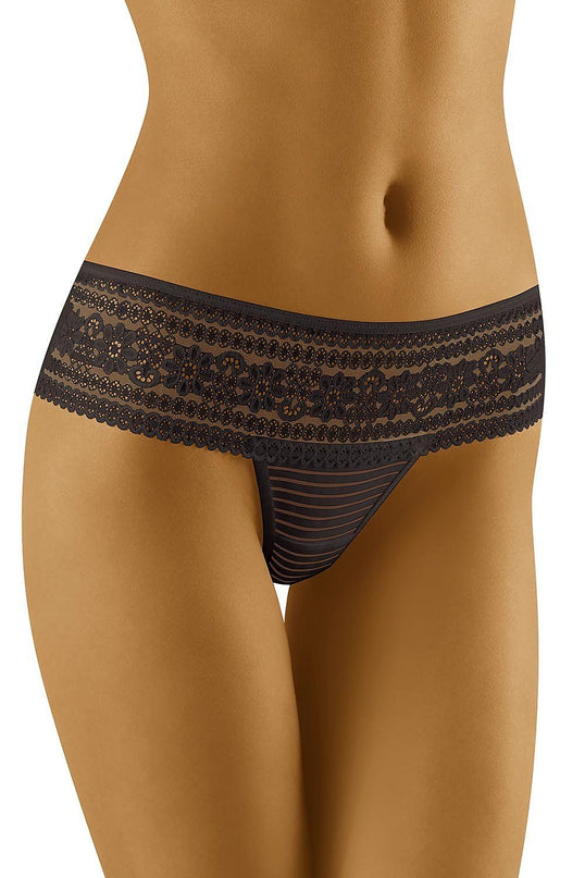 A model stands against a plain white background wearing a black lace low-rise thong with a striped mesh front panel