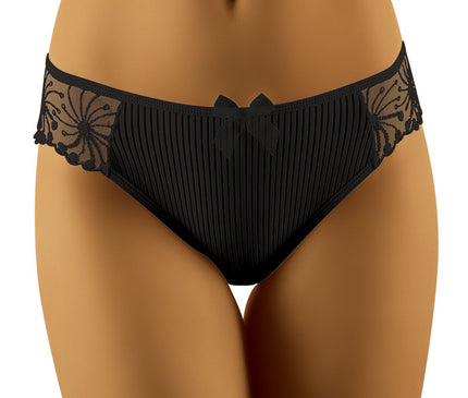 Model standing front on a white studio background wearing low-rise black pleated briefs with mesh lace side panels