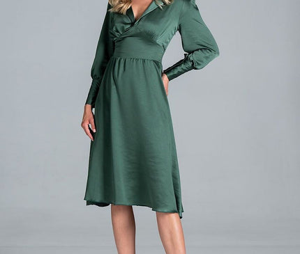 A female model posing against a plain grey background wearing a deep green satin long-sleeve V-neck midi dress with a fitted waist and flared skirt