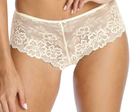 Model standing front-on wearing cream lace low-rise hipster panties with a floral pattern and one hand resting at her waist against a plain white background