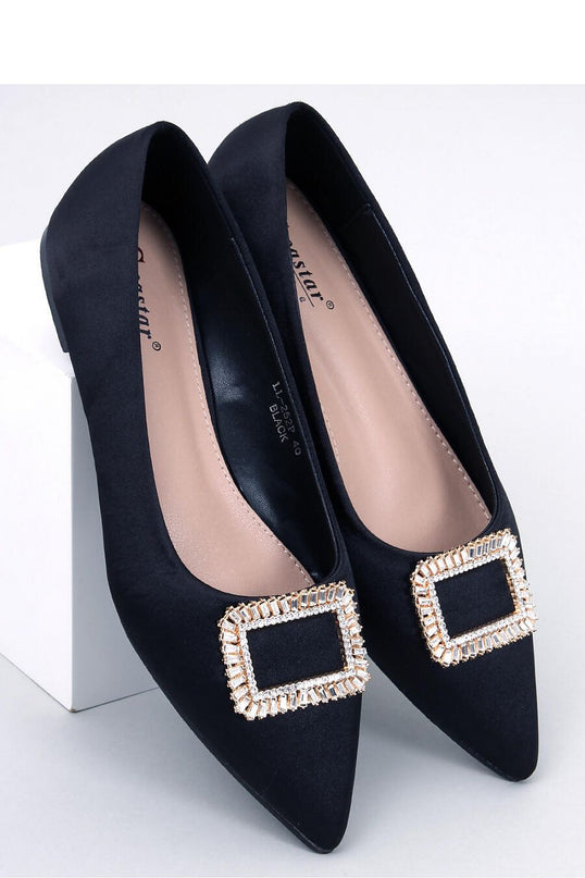 Black satin pointed-toe flat shoes topped with a crystal-embellished square buckle angled on a white block against a plain white background