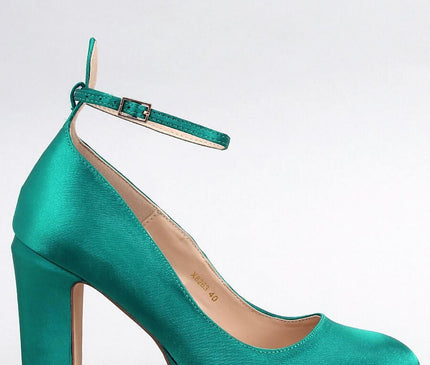 Emerald green satin platform pump with ankle strap in side profile against a white background