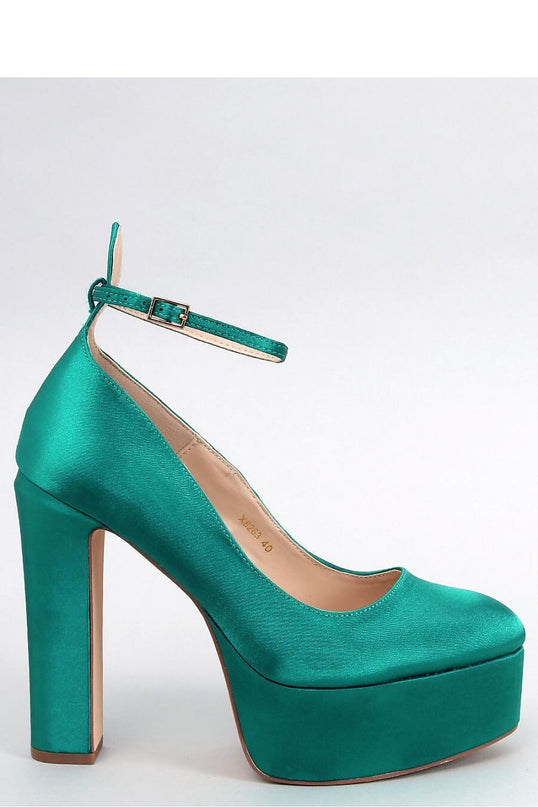 Emerald green satin platform pump with ankle strap in side profile against a white background