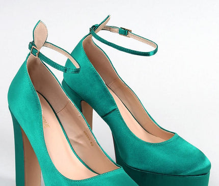 Emerald green satin platform high-heeled shoes with closed round toes and ankle straps displayed on a plain white background