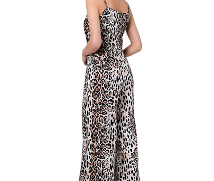 a female model wearing a silky brown and black leopard print cami jumpsuit with wide legs and spaghetti straps standing in profile against a white background