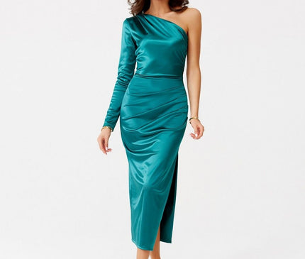 A female model walking in a one-shoulder emerald green satin bodycon midi dress with long sleeve and side slit against a plain white studio background