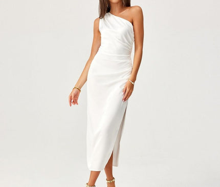 Female model stands in front of a plain white studio backdrop wearing a white satin one-shoulder bias-cut midi dress with a side slit in a relaxed standing pose